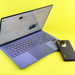A sleek laptop and smartphone set against a vibrant yellow background, showcasing modern technology.